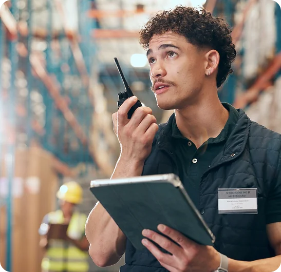 Profissional usando rádio comunicador e tablet em operação industrial