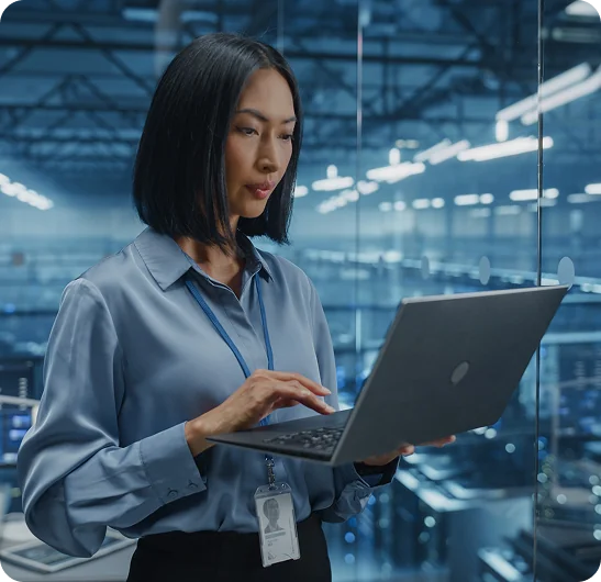 Profissional acessando o sistema em um notebook dentro de ambiente industrial